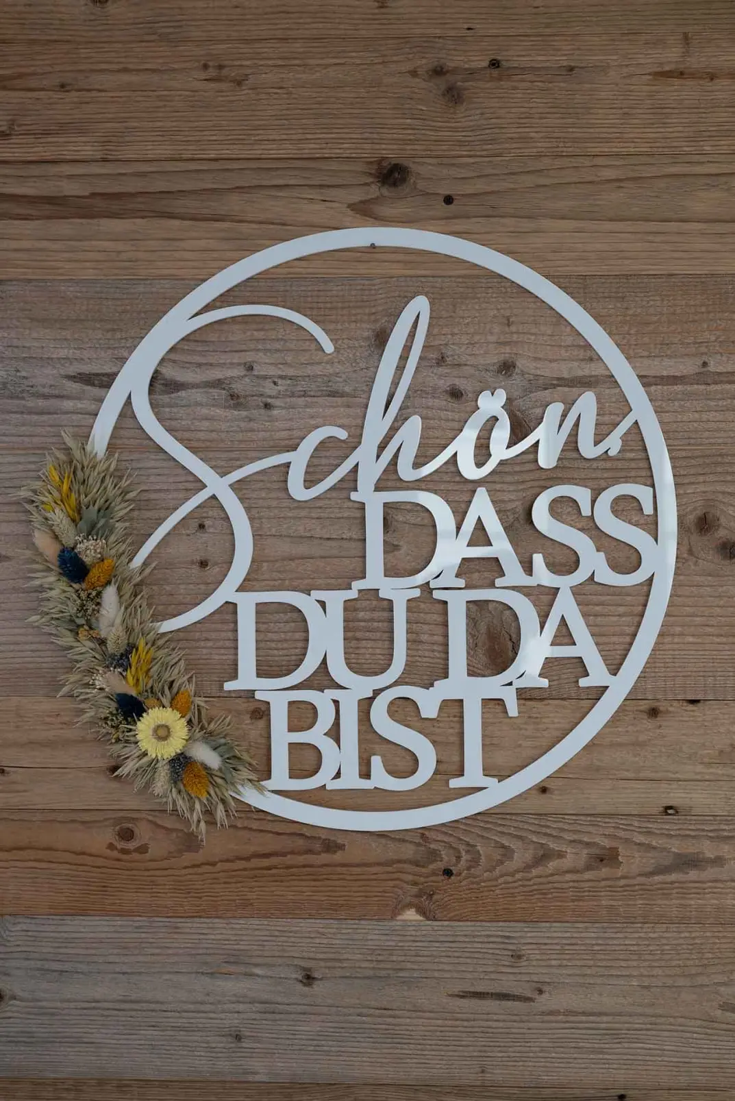 Schild an Holzwand mit dem Spruch: Schön, dass du da bist